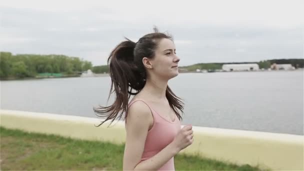 En ung kvinna med en slank figur kör. Slow motion kamera — Stockvideo