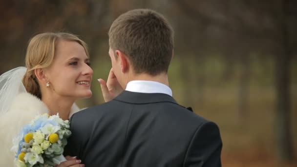 秋の公園でウォーキング新婚夫婦の笑顔幸せな結婚式のカップル — ストック動画