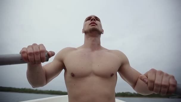 Musclé homme fort rangée de vieux bateau, flottant sur un bateau avec des rames. Mouvement lent . — Video