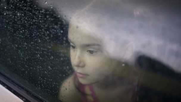 Child female in the car in raining — Stock Video