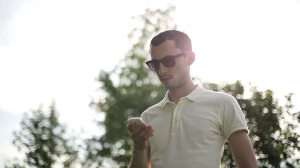 Mannen i solglasögon utomhus prata i telefon på sunset ultrarapid — Stockvideo