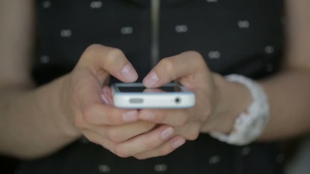 Νεαρή γυναίκα μαύρο φόρεμα δάχτυλα πληκτρολογώντας στο smartphone σε κοντινό πλάνο — Αρχείο Βίντεο
