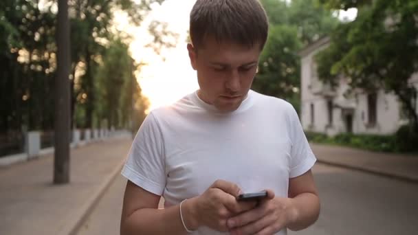 Mann mit Smartphone zu Fuß. Zeitlupe — Stockvideo