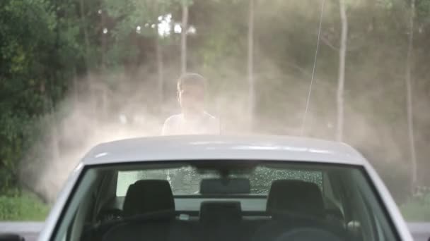 Hombre en una camiseta blanca lavado de autos blanco . — Vídeo de stock