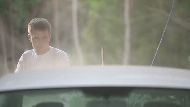 Man in a white t-shirt white car washes. — Stock Video