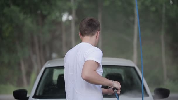 Homem em uma camiseta branca lavagens de carro branco . — Vídeo de Stock