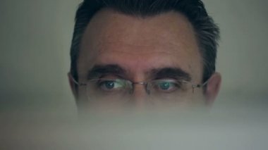 Bir bilgisayarda çalışan orta yaşlı adam