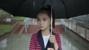 Bir şemsiye ile yağmurda kız yalnız çocuk. Ağır çekim.