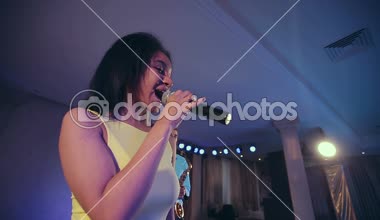 Koyu tenli siyah kadın caz şarkıcısı mikrofon sahnede şarkı söylemek.