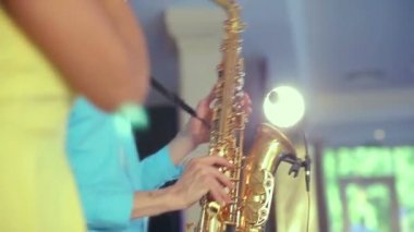 Caz kadın şarkıcı ve ince saksafon çalar. Yaratıcı ikilisi. Stüdyo ışıkları. Ağır çekim