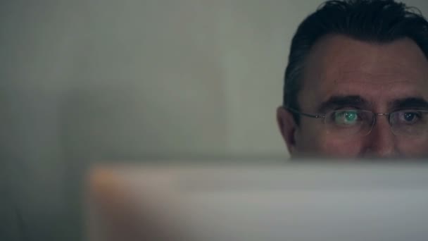 Middelbare leeftijd man aan het werk op een computer — Stockvideo