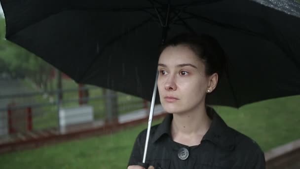 Uma mulher solitária à chuva com um guarda-chuva. Movimento lento . — Vídeo de Stock