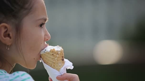 Mooi kind meisje eten van ijs op de straat. — Stockvideo