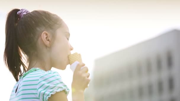 Bella bambina bambina che mangia gelato per strada . — Video Stock