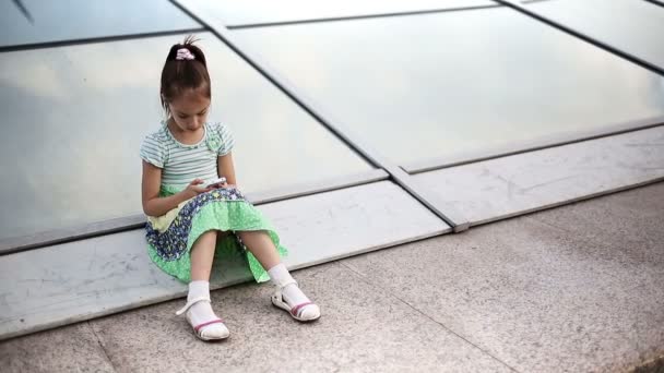 Mooi kind klein meisje kind geniet smartphone. — Stockvideo