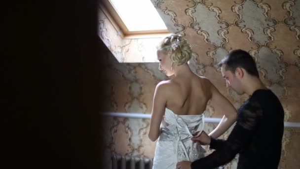 Bride dresses before a mirror, it helps her fiance — Stock Video