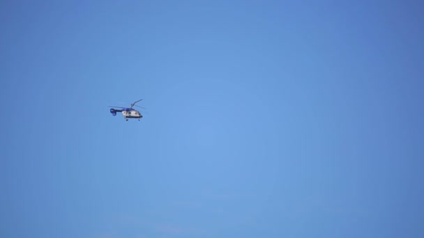 Pequeño helicóptero vuela sobre fondo azul cielo — Vídeos de Stock