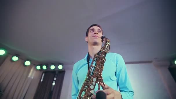 El saxofonista actúa en el escenario con luz profesional . — Vídeos de Stock