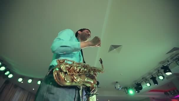 Saxofonist voert op het podium met professionele licht. — Stockvideo