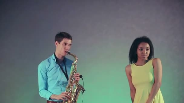 Jazz kvinna sångaren och tunna saxofon spelare. Den kreativa duon. Studioljus. Slow motion — Stockvideo