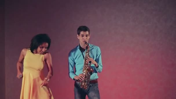 Jazz vrouw zanger en dunne saxofonist. De creatieve duo. Studio lampen. Slow motion — Stockvideo