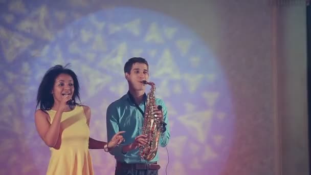 Jazz woman singer and thin saxophone player. The creative duo. Studio lights. Slow motion — Stock Video