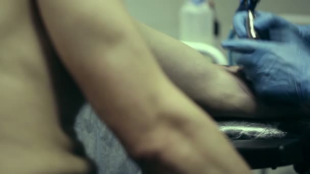 Καλλιτέχνης τατουάζ που εργάζονται. Άνθρωπος που εμπνέεται από το πρόσωπο της γυναίκας του βραχίονα. Σαλόνι τατουάζ — Αρχείο Βίντεο