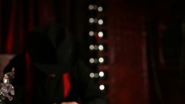 Gangster bir puro sigara bir masada oturan ve yüzünü bir şapkaya gizler