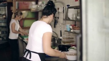 Restoran mutfak kadın hazırlanıyor balık yemekleri Konuklar için. Orta atış.