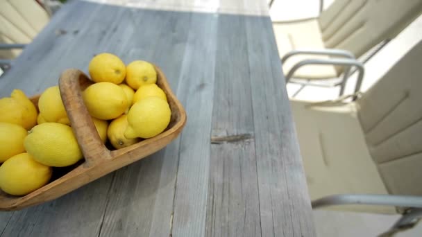 Limones en una canasta sobre una mesa de madera. Disparo HD con control deslizante — Vídeo de stock