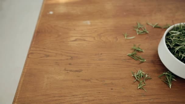 Kom met rozemarijn op een houten tafel — Stockvideo
