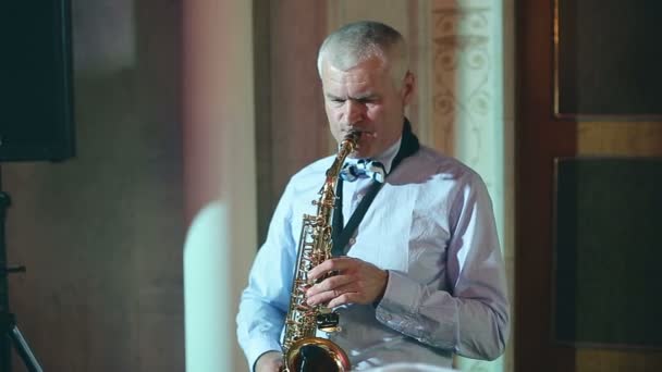 Hombre saxofonista de mediana edad 50 años tocando un saxofón instrumento musical . — Vídeo de stock