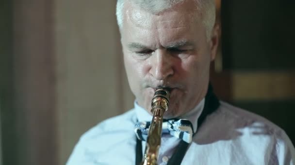 Hombre saxofonista de mediana edad 50 años tocando un saxofón instrumento musical . — Vídeos de Stock