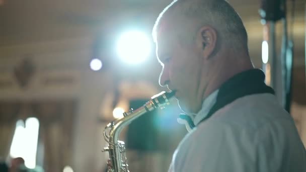 Hombre saxofonista de mediana edad 50 años tocando un saxofón instrumento musical . — Vídeos de Stock