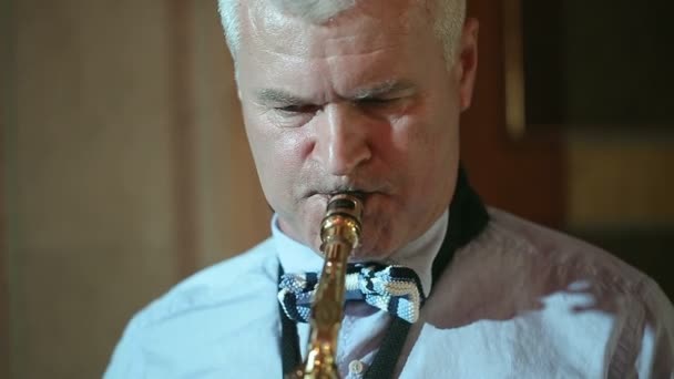 Hombre saxofonista de mediana edad 50 años tocando un saxofón instrumento musical . — Vídeo de stock