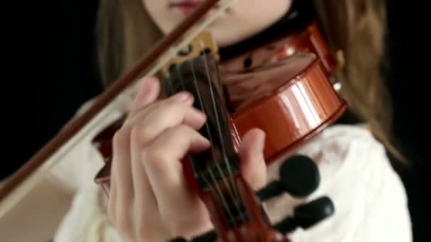 Menina violinista caucasiana em um fundo preto . — Vídeo de Stock