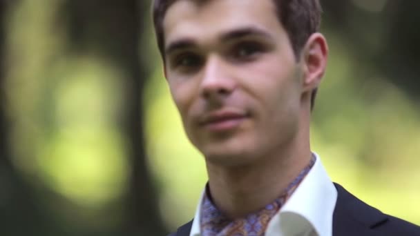 Portrait of young handsome groom on the nature — Stock Video