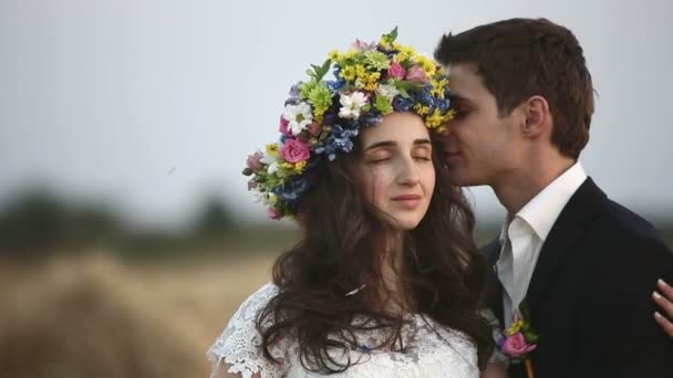 Muž nosí na hlavě dívky věnec z květin. — Stock video