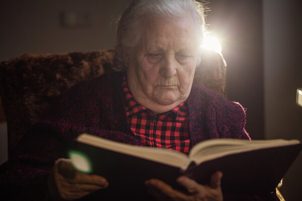 Old human reading a book.