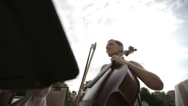 Музичний квартет. Дівчина грає на віолончелі в квартеті скрипалів . — стокове відео
