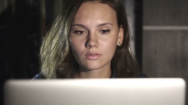 Dívka pracuje na počítači večer v interiéru s pozadím vodou, která symbolizuje tok myšlenek. — Stock video
