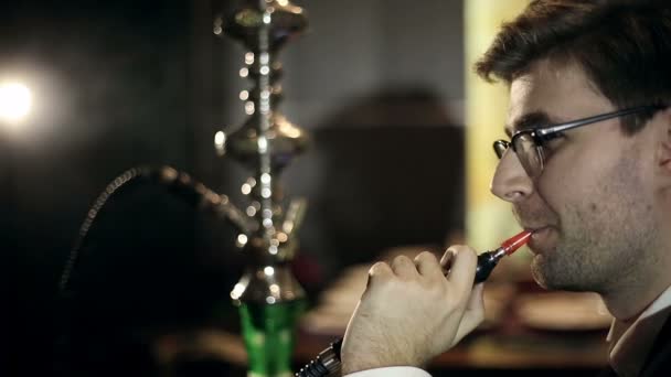 Junger intelligenter Mann raucht Wasserpfeife — Stockvideo