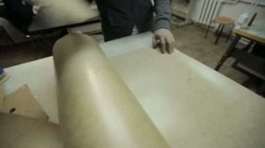 Fabrikada çalışan adam. Çanta yapmak için karton çerçeve keser.