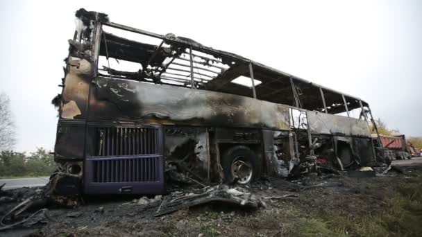 Згорілий пасажирський автобус на стороні дороги — стокове відео