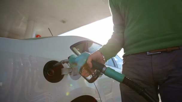 Ένας άνθρωπος γεμίζει ένα λευκό αυτοκίνητο ποιότητας βιοκαυσίμων με την Ανατολή — Αρχείο Βίντεο
