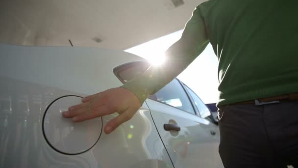 Een man vult een witte auto kwaliteit biobrandstoffen bij zonsopgang — Stockvideo