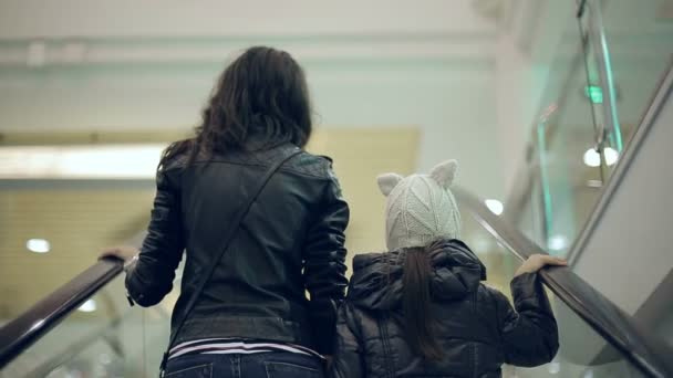 Mère et fille dans un supermarché sur l'escalier roulant . — Video