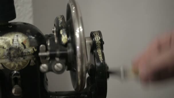 Machine à coudre main masculine tourne la roue. Gros plan .