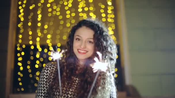 Retrato de uma menina modelo olha com sparklers em suas mãos — Vídeo de Stock