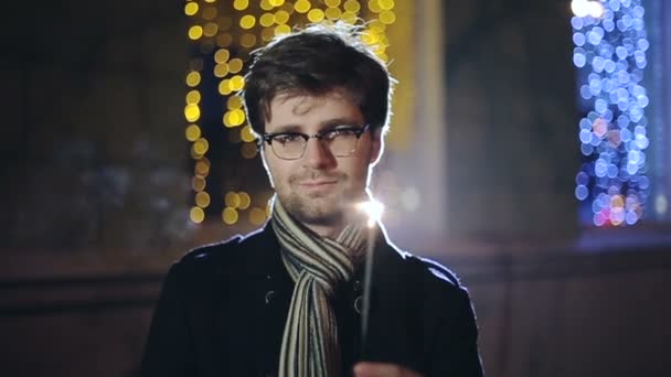 SLOW MOTION: Portrait of man with a sparkler in hand bokeh background — Stock Video